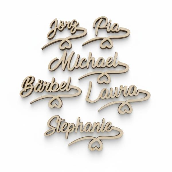 Filigran gelaserter Holzname mit Herzanhänger, klar und minimalistisch präsentiert.